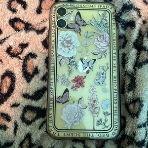 A clear iPhone 11 case with butterfly and plants on it